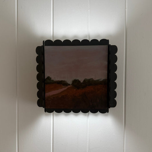 Decorative wall light fixture on a white paneled wall